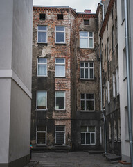 Fototapeta premium An old neglected yard with a dilapidated tenement house.