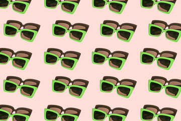 Creative pattern made of bright green sunglasses on pastel pink background. Summer fashion concept. Minimal style. Top view. Flat lay