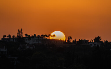 Fototapeta na wymiar Sunset over the roofs of houses in Protaras, Cyprus