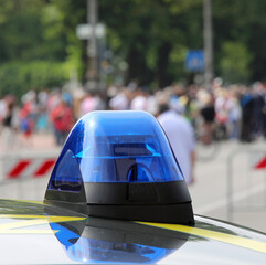Obraz premium blue light siren of police car and unrecognizable people