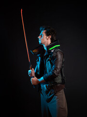A guy in a cyberpunk image. Cyborg samurai holds a tuned sword in his hands. A young man in neon...