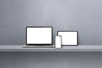 Laptop, mobile phone and digital tablet pc on grey wall shelf. Horizontal background