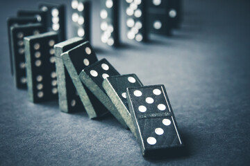 Black dominoes chain on dark table background