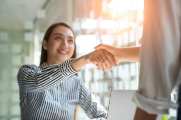 Asian business partners successfully handshake together in a modern office. Partnership approval...