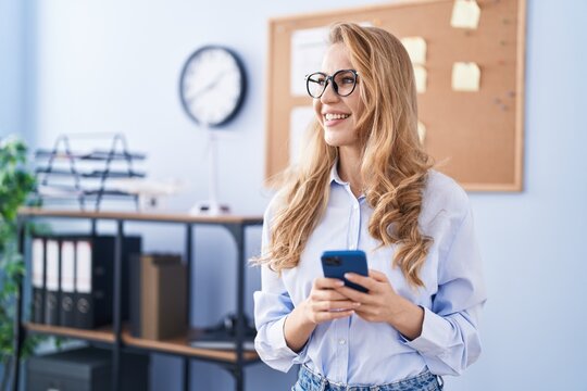 Young blonde woman business worker using smartphone at office