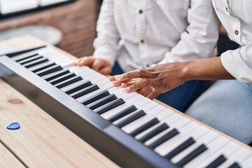 African american mother and son student learning play piano at music studio