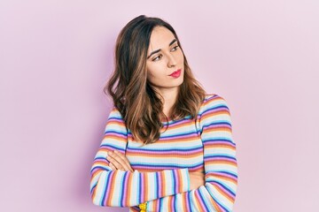 Fototapeta premium Young hispanic girl wearing casual clothes looking to the side with arms crossed convinced and confident