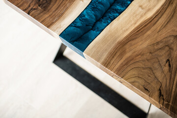 Obraz na płótnie Canvas table made of natural wood and blue epoxy