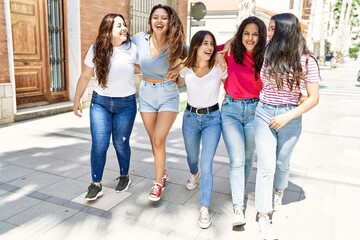 Group of young women friends smiling happy walking at the city.