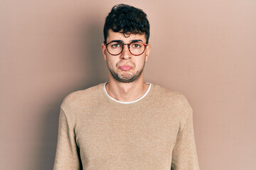 Young hispanic man wearing casual clothes and glasses depressed and worry for distress, crying angry and afraid. sad expression.