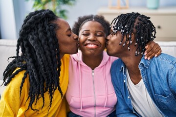 African american friends hugging each other and kissing sitting on sofa at home