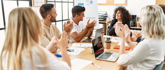 Group of young business workers smiling and clapping to partner at the office.