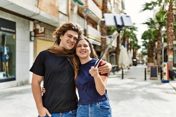 Young caucasian couple smiling happy standing at the city.