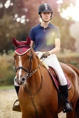 Foto op Canvas Portrait of jockey woman rider with brown horse, concept advertising equestrian club school. © Linas T