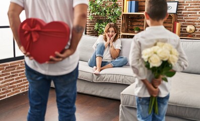 Family surprise mother with gift and flowers on back at home
