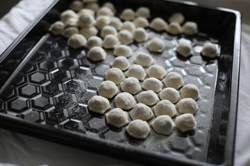 raw frozen dumplings on a black dish