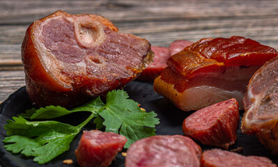 Ingredients for feijoada, sausage, bacon, pork knuckle and raw pork meat on wooden background