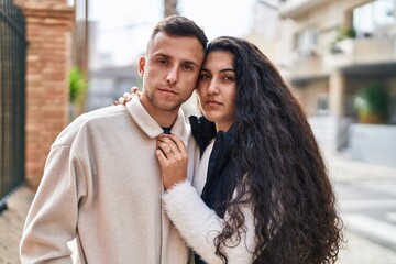 Man and woman couple standing together with relaxed expression at street