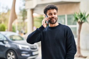 Young arab man smiling confident talking on the smartphone at street