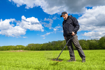 Archaeologist with metal detector. Man archaeologist stands at edge of forest. Equipment for...