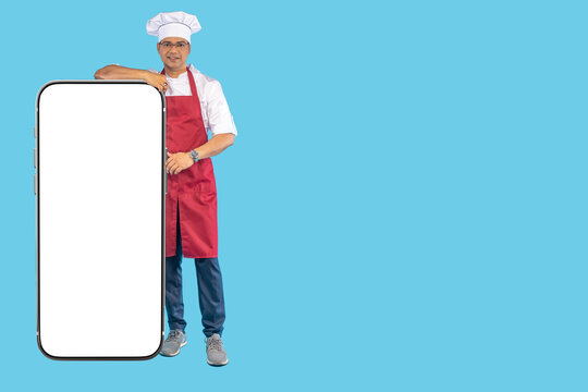 Man chef with phone. Big phone and restaurant chef. Apps recommendation for new restaurant. Space for advertising on phone display. Cook service ads. Chef mobile app. Cook guy on turquoise background