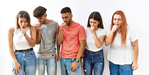 Group of young friends standing together over isolated background feeling unwell and coughing as symptom for cold or bronchitis. health care concept.