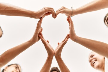 Group of young friends with hands together doing heart symbol.