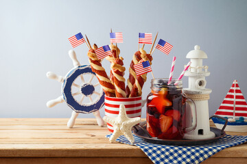 4th of July  picnic concept  with summer fresh fruit drink, twisted hot dog sausages and nautical decorations on wooden table. Independence Day concept