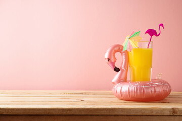 Retro aesthetic 80s concept  with orange juice and flamingo pool float. Summer vacation vibes...