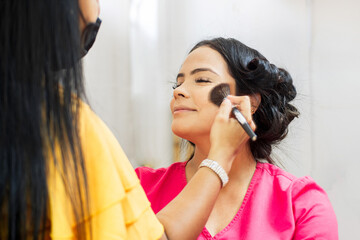 Makeup artist using brushes dusting cheeks.