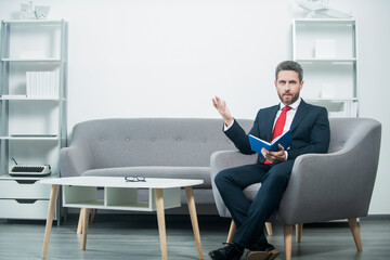 mature businessman in suit sit making notes in planner