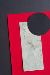 black paper circle on green marbled and red paper background