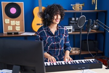 Young middle east woman musician playing piano keyboard at music studio