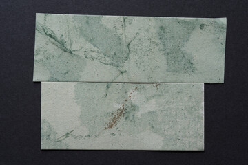 two pieces of grungy marbled paper on gray