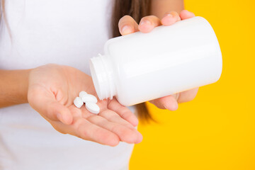 Bottle of vitamin pills in hand, healthy lifestyle. Presenting capsule shape tablet for kids.