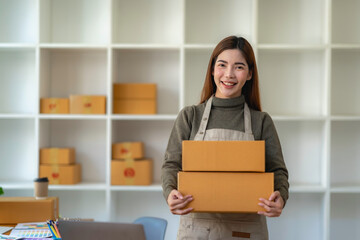Startup small business SME, Entrepreneur owner working in home office with boxes, checking online purchase shopping order to preparing pack product box. Selling online ideas concept