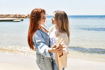 Young lesbian couple of two women in love at the beach. Beautiful women together dancing at the beach