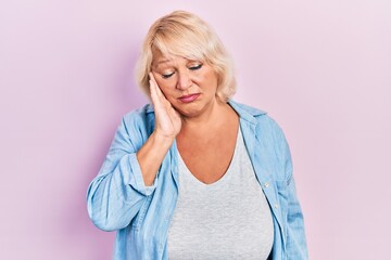 Middle age blonde woman wearing casual clothes thinking looking tired and bored with depression problems with crossed arms.