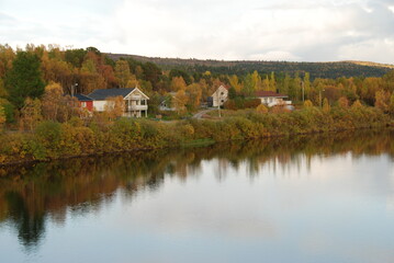 Fototapeta premium Karasjok village in autumn colors reflected in Karasjohka River, Finnmark, Norway 