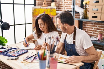 Middle age man and woman artists drawing on notebook at art studio