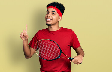 Young african american man wearing tennis player uniform smiling with an idea or question pointing finger with happy face, number one