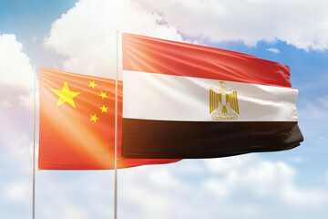 Sunny blue sky and flags of egypt and china