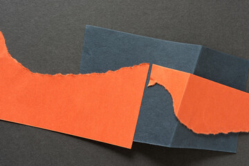 torn orange paper on blue and gray paper