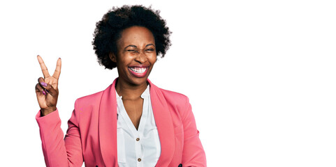 African american woman with afro hair wearing business jacket smiling with happy face winking at the camera doing victory sign with fingers. number two.