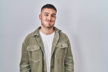 Obraz premium Young hispanic man standing over isolated background puffing cheeks with funny face. mouth inflated with air, crazy expression.