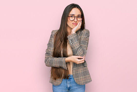 Young hispanic girl wearing business clothes and glasses thinking looking tired and bored with depression problems with crossed arms.