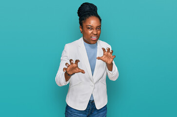 Young african american woman wearing business clothes smiling funny doing claw gesture as cat,...
