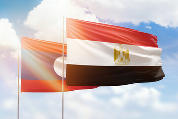 Sunny blue sky and flags of egypt and laos