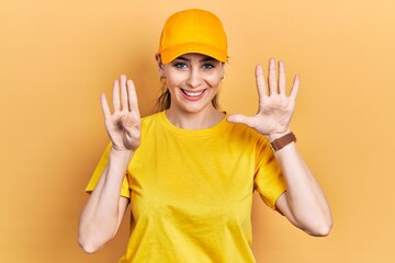 Young hispanic woman wearing delivery uniform and cap showing and pointing up with fingers number...