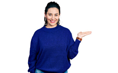 Fototapeta premium Young hispanic woman wearing casual clothes smiling cheerful presenting and pointing with palm of hand looking at the camera.